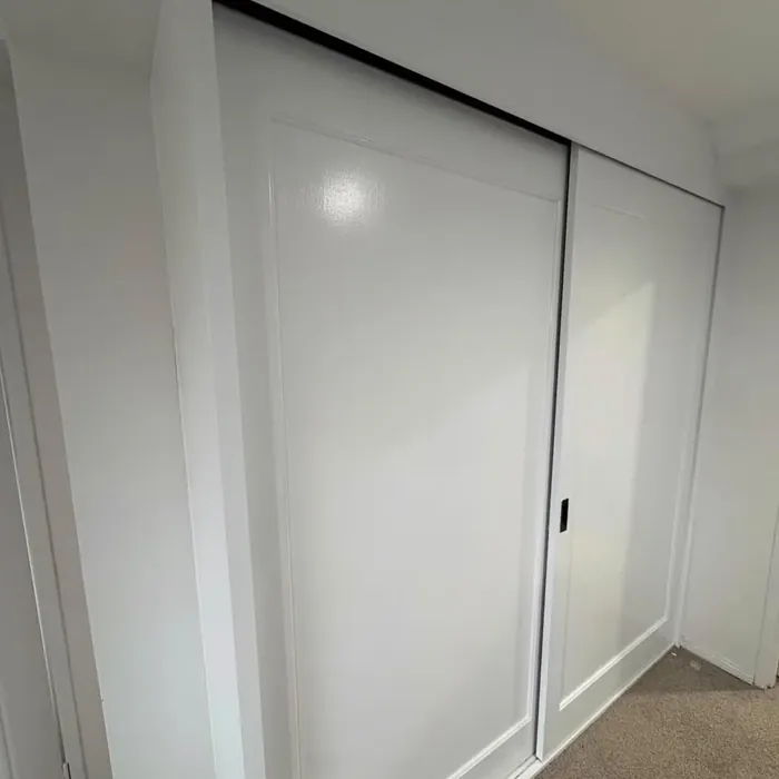 The same wardrobe after respraying: sliding doors and surround in clean white.