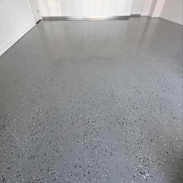 The same garage floor after coating: an even grey flake finish with a satin sheen.