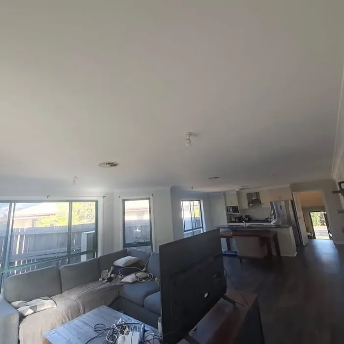 The same living room finished and back in use, with a freshly painted white ceiling.