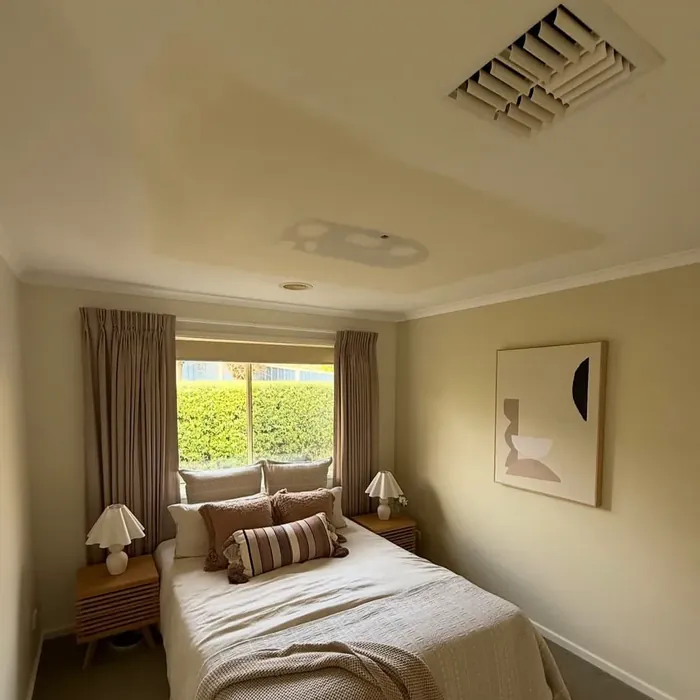 Bedroom with a yellowed ceiling showing a discoloured patch around the light fitting.