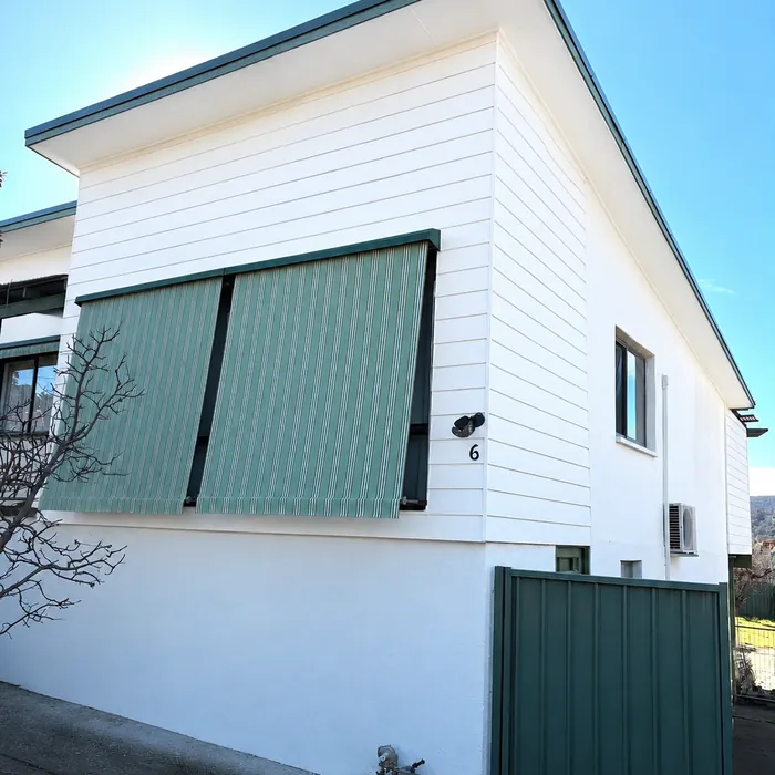 The same corner freshly painted white, with the awning and window shutters back in place.