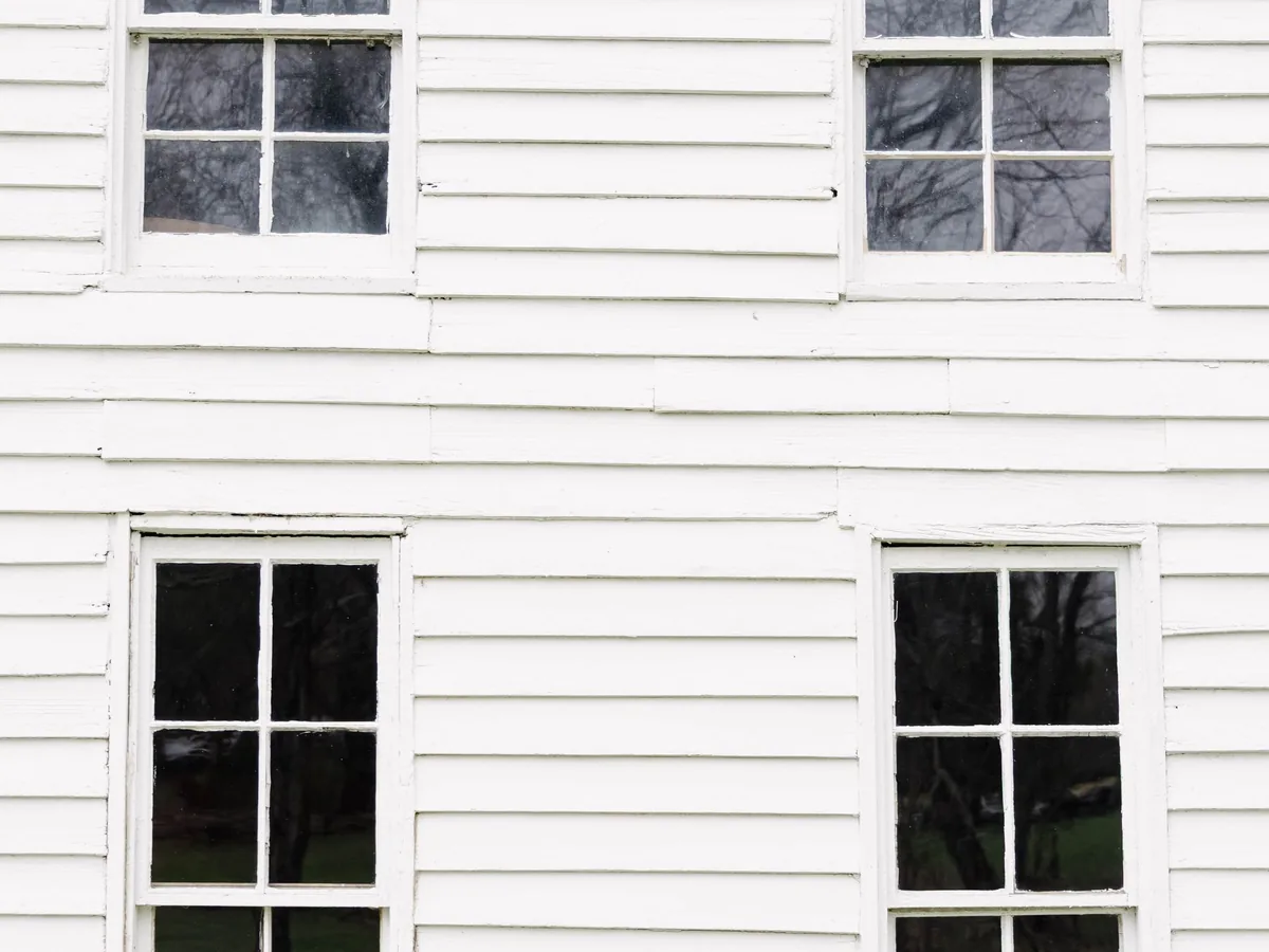 White painted weatherboard cladding with double-hung timber windows.
