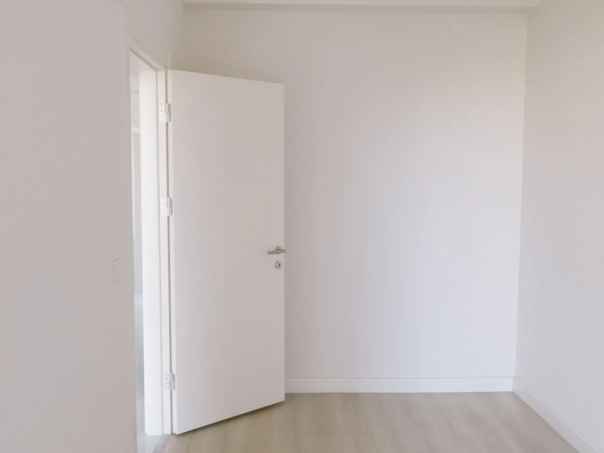 White painted door and architrave against a white wall.